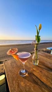 Una bebida y un jarrón de flores en una mesa en la playa. en Departamento Exclusivo TSM, Santo Domingo, en Santo Domingo