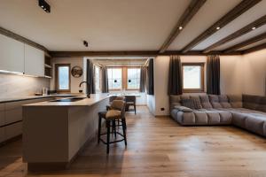a kitchen and living room with a couch and a table at Ciasa Bel Marin in La Villa