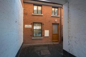 a brick building with a door and a window at Cosy Coach House - Belfast in Belfast