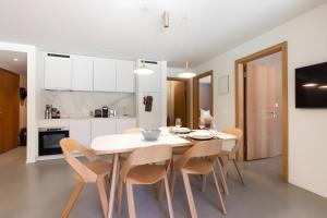 a kitchen and dining room with a white table and chairs at Ferienwohnung Stenna Allegra in Flims +46 photos