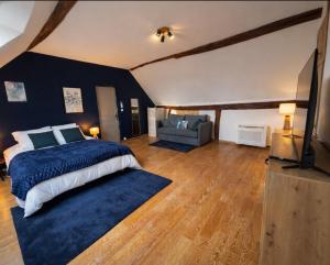 - une chambre avec un grand lit et un tapis bleu dans l'établissement Le terroir des sens, à Corgengoux