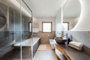a bathroom with a sink and a tub and a toilet at Ciasa Bel Marin in La Villa +45 photos