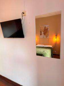 une télévision accrochée au mur dans une chambre dans l'établissement HOTEL MONTANAS, à Nova Friburgo