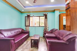 un soggiorno con mobili in pelle viola e pareti blu di Super Hotel O Kanyakumari Near Sunrise View formerly Jaisas Paradise a Kanyakumari