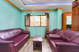 soggiorno con divani in pelle viola e tavolo di Super Hotel O Kanyakumari Near Sunrise View formerly Jaisas Paradise a Kanyakumari