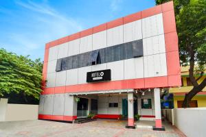 un edificio bianco e rosso con un cartello sopra di Super Hotel O Kanyakumari Near Sunrise View formerly Jaisas Paradise a Kanyakumari Altre 27 foto