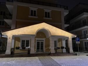 een groot geel gebouw met een verlichte gevel bij Danubia-residence in Komárno +1 foto