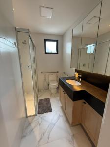 un bagno con wc, lavandino e doccia di JD Village a Itapema
