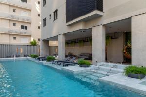 a swimming pool in front of a building at JD Village in Itapema