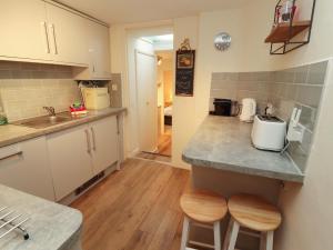 een keuken met een aanrecht en 2 krukken bij Archers in Keswick