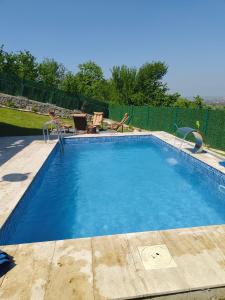 a swimming pool with blue water in a yard at YAKUT bungalow in Akyazı