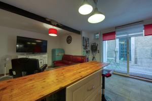 une cuisine avec un comptoir en bois et un salon dans l'établissement Studio NEW YORK, à Alignan-du-Vent