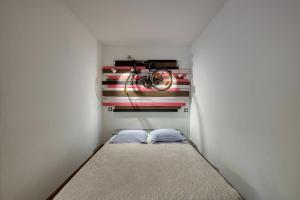 une petite chambre avec un lit et un vélo accroché au mur dans l'établissement Studio NEW YORK, à Alignan-du-Vent