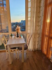a table and chairs in a room with a window at Новобуд з кондиціонером ЖК "Яровиця 11" in Lutsk