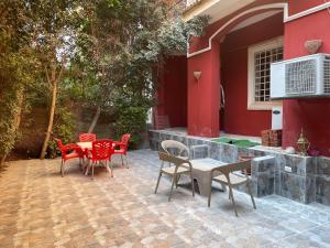 a patio with red chairs and a table and a building at مصر مدينة الشيخ زايد in Sheikh Zayed