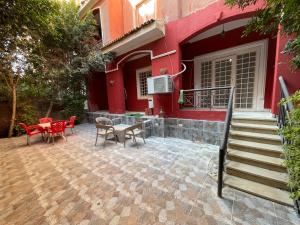a patio with a table and chairs and a red house at مصر مدينة الشيخ زايد in Sheikh Zayed +13 photos
