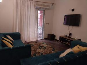 a living room with a blue couch and a television at مصر مدينة الشيخ زايد in Sheikh Zayed