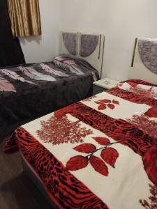a bedroom with two beds with red leaves on them at مصر مدينة الشيخ زايد in Sheikh Zayed