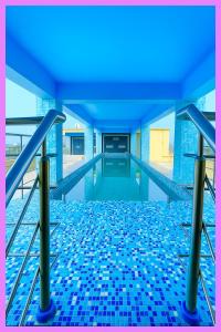 einen Pool mit blauen Bodenfliesen in der Unterkunft Hotel Coral Premium Suite Near Jagannath Temple - Sea Beach - Lift Free Parking & Swimming Pool - Best Prime Location Hotel in Puri