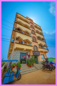 ein Gebäude mit einem Roller, der davor geparkt ist in der Unterkunft Hotel Coral Premium Suite Near Jagannath Temple - Sea Beach - Lift Free Parking & Swimming Pool - Best Prime Location Hotel in Puri