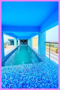 einen Pool mit blauen Bodenfliesen in der Unterkunft Hotel Coral Premium Suite Near Jagannath Temple - Sea Beach - Lift Free Parking & Swimming Pool - Best Prime Location Hotel in Puri