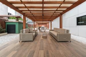 a covered patio with two couches and a table at Studio completo em Barueri - Selenita #8 in Barueri