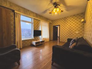 a living room with a couch and a tv at MAER'S Hotel in Qusar