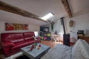 een woonkamer met een rode bank en een tafel bij Bien-être in Alignan-du-Vent