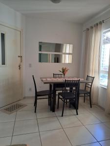 een eetkamer met een tafel met stoelen en een spiegel bij Ilhéus in Ilhéus