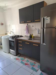 een keuken met een roestvrijstalen koelkast en een tegelvloer bij Ilhéus in Ilhéus