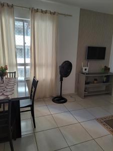 een woonkamer met een tafel en een ventilator bij Ilhéus in Ilhéus