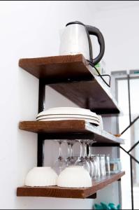 a shelf with plates and a tea pot on it at Lumora Deluxe Apartment in Tanga