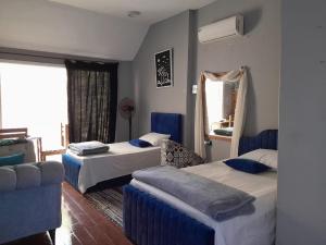 una camera d'albergo con due letti e un divano di iBiZa Hostel a Beni Suef