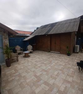 un grand patio avec un bâtiment avec un toit dans l'établissement Cabana 01, à Imbituba