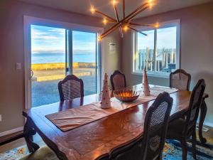 een eettafel met stoelen en een groot raam bij Sq Seaside Cottage in Sequim
