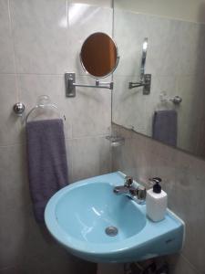 a bathroom with a blue sink and a mirror at 01 Comodo apartamento equipado in Maracay +14 photos