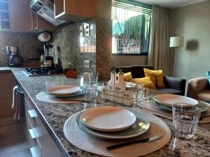 a kitchen with a table with plates and glasses on it at 01 Comodo apartamento equipado in Maracay