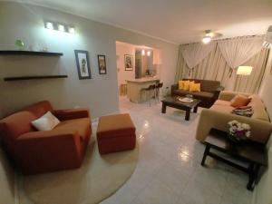 a living room with couches and chairs and a table at 01 Comodo apartamento equipado in Maracay