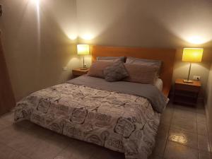 a bedroom with a large bed with two lamps at 01 Comodo apartamento equipado in Maracay