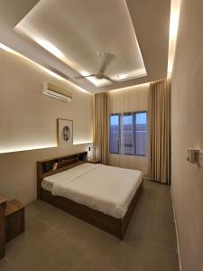 een slaapkamer met een groot bed en een raam bij Sinkhole Chalet in Bimmah +52 foto's