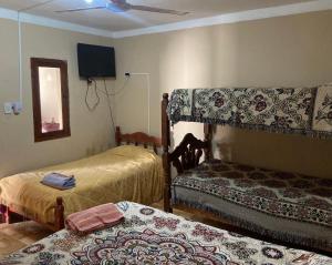 una camera con due letti e una TV a schermo piatto di Hostal las Margaritas a Salta