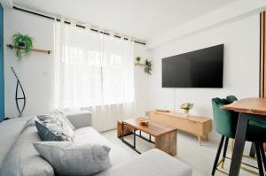a living room with a couch and a tv at Appartement Dinard hyper centre, 2 chambres in Dinard