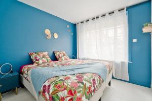 a blue bedroom with a bed and a blue wall at Appartement Dinard hyper centre, 2 chambres in Dinard