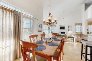 una sala da pranzo e un soggiorno con tavolo e sedie di Bear Trap Dunes 53D Willow Oak Ave a Ocean View