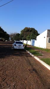 una macchina bianca parcheggiata sul lato di una strada sterrata. di Casa MARAIMAU a Encarnación