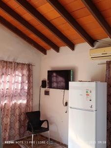una cucina con frigorifero e sedia in una stanza di Casa MARAIMAU a Encarnación