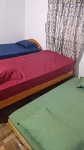 due letti uno accanto all'altro in una stanza di Casa MARAIMAU a Encarnación