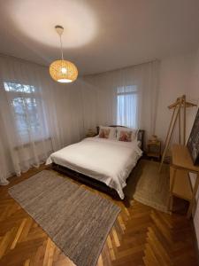 OveseluCasa de Vacanta Nora的卧室里有一张白色的床和一盏枝形吊灯