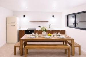 a kitchen with a wooden table and a white refrigerator at Le JoliCoeur Parking gratuit Idéal cyclistes Proche Alpe d Huez in Le Bourg-dʼOisans +8 photos