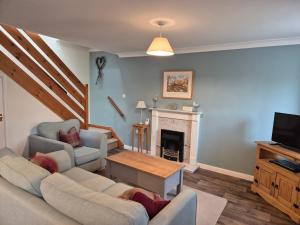 een woonkamer met een bank en een open haard bij Westgate Cottage in Pickering +11 foto's